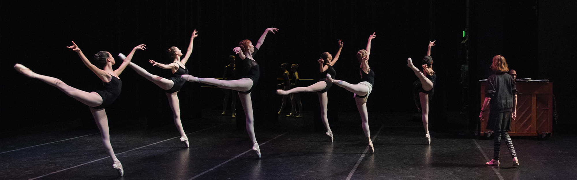 A captivating performance by a group of ballet dancers gracefully moving on stage.
